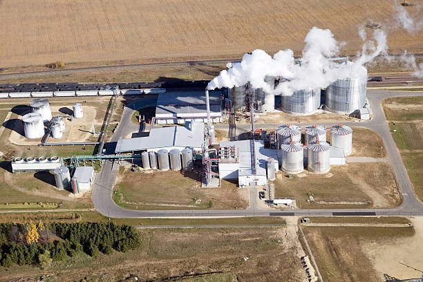 Ethanol Biorefinery Fall Aerial View An Ethanol plant shot from the open window of a small airplane on an early autumn day.  The cornfield in the background has been recently harvested. corn biodiesel crop corn crop stock pictures, royalty-free photos & images
