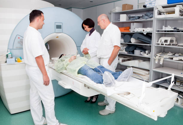 istock Young girl in MRI machine...doctors and technician consulting 157694179