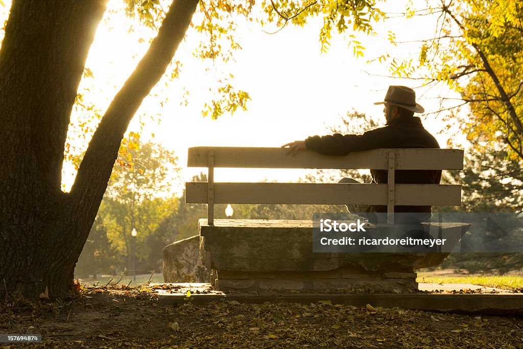 Homme d'âge mûr se situe bien sur le banc dans le parc en automne - Photo de Troisième âge libre de droits