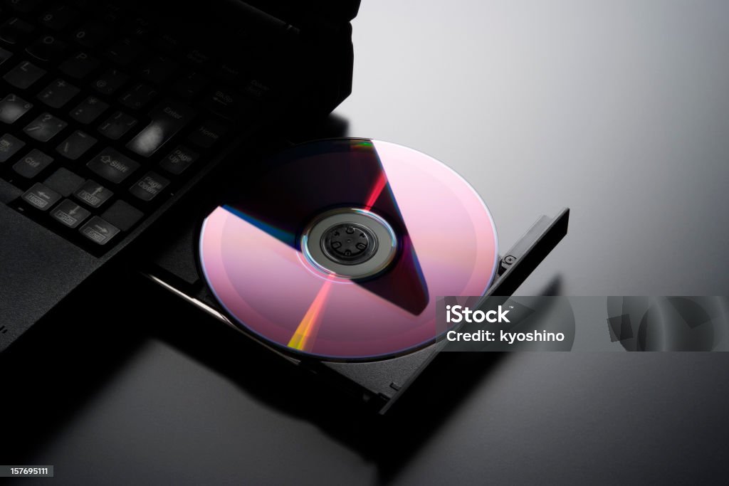 CD を挿入するには、ノートパソコ��ン - CD-ROMのロイヤリティフリーストックフォト