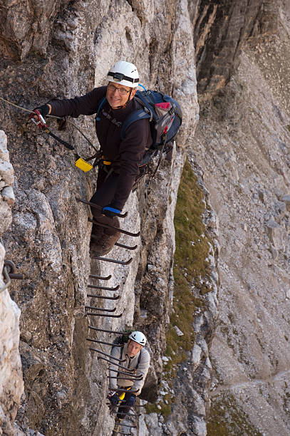 istock Via ferrata climbers on iron ladder 157695137