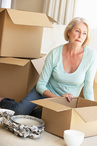 istock Senior Woman Moving Home And Packing Boxes 157695323