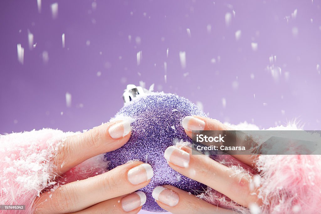 Christmas theme manicure Womans hand in fingerless puffy gloves holding a christmas bauble Christmas Stock Photo