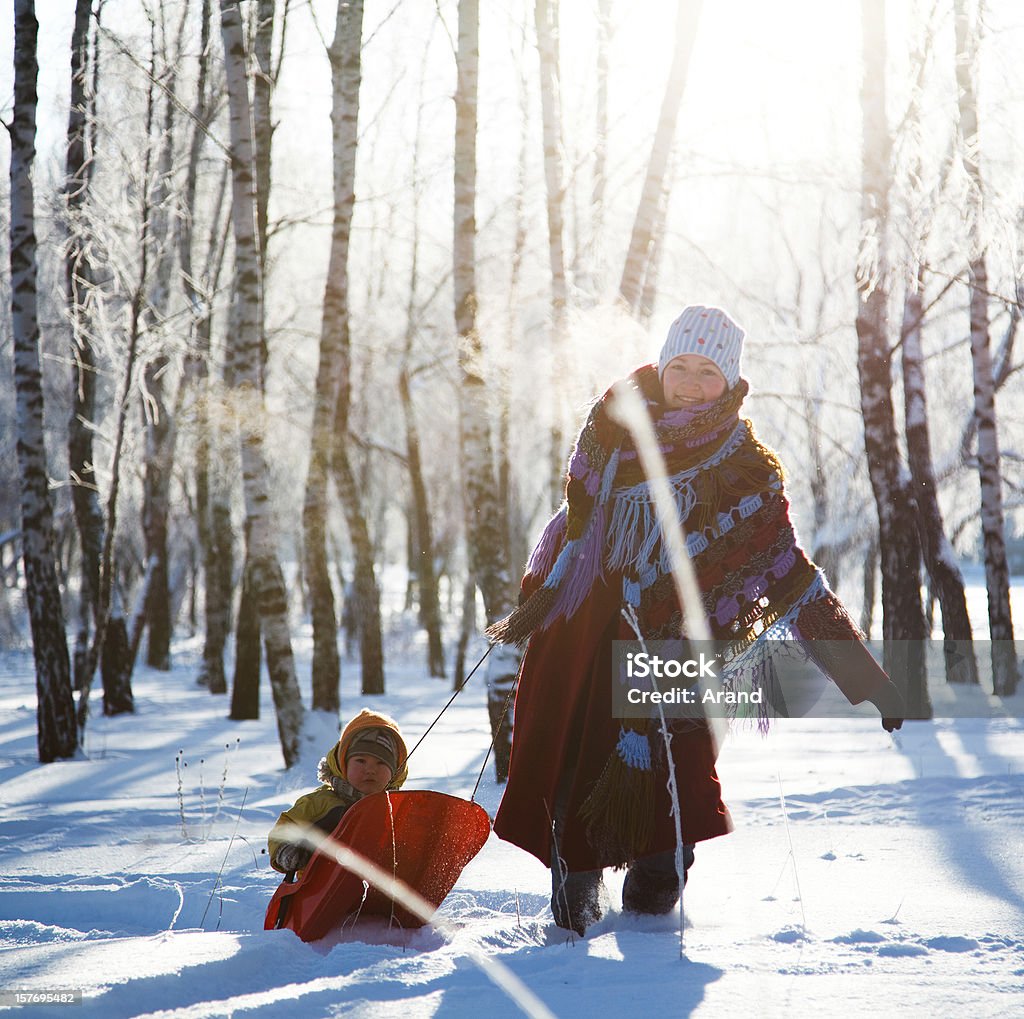 family having fun in winter family having fun in winter, running with sled. Activity Stock Photo