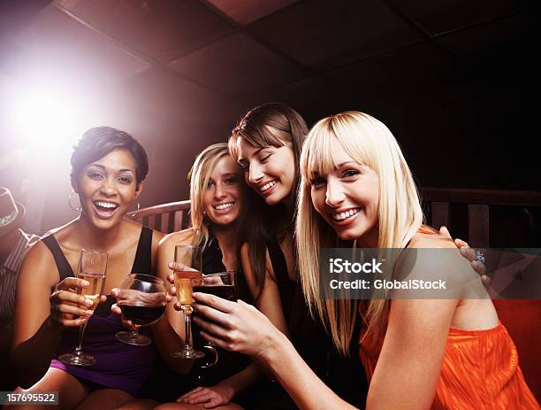 Night Club Smiling Young Female Friends Enjoying Drinks Stock Photo - Download Image Now