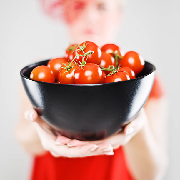 kobieta gospodarstwa pomidory infront jej - cherry tomato flash zdjęcia i obrazy z banku zdjęć