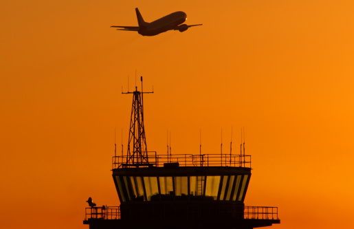 Airport control tower with airplane taking off.
