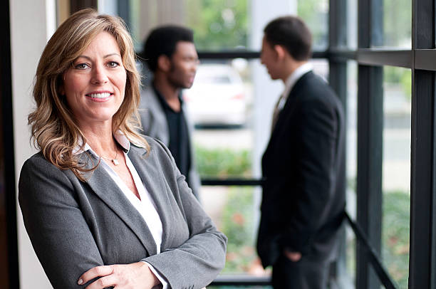 Confident Business Woman and Employees stock photo