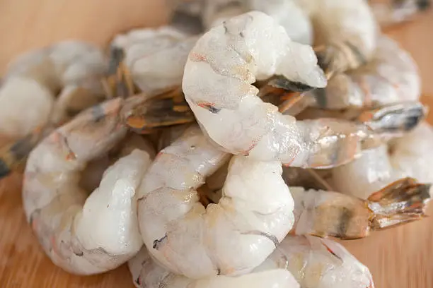 Photo of Pile of shrimp on a wooden countertop