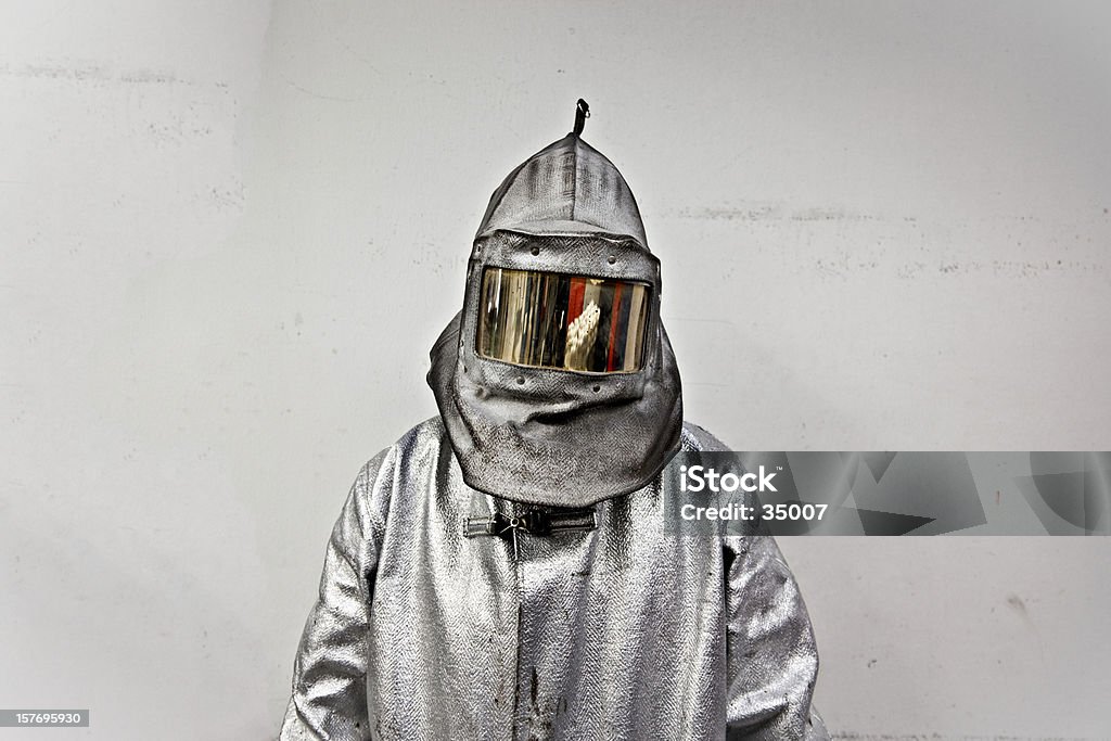 Portrait of a steel worker in a silver suit with a hood steel worker in protective workwear. Protective Suit Stock Photo