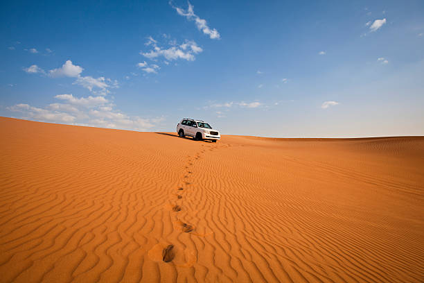 4WD car and footprints in the desert stock photo