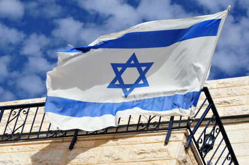 An Israeli flag flies from a balcony in Safed, Israel