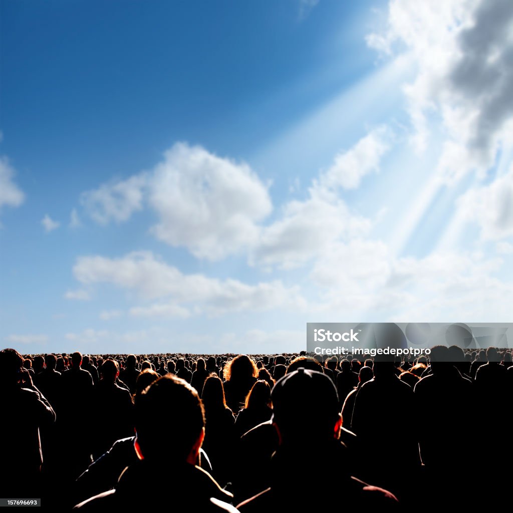 crowded people over sunny sky large group of people walking towards sunlight. Protest Stock Photo