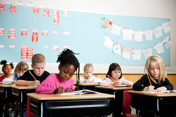 School kids First graders in a classroom  elementary age stock pictures, royalty-free photos & images