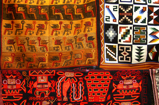 Vibrant colors of a traditional Andes textile on the local art and craft market of Otavalo, Ecuador. Textiles are found in the Andes countries of Bolivia, Ecuador and Peru.