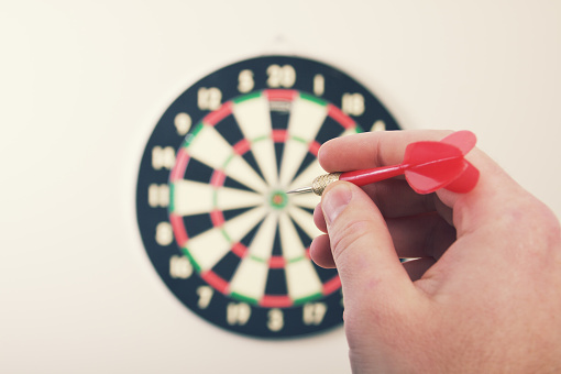 a player getting ready to throw a dart at a dart board.