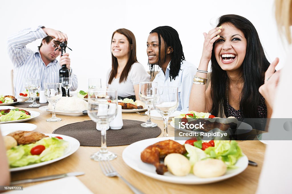 Happy young people gathered round dining table  20-29 Years Stock Photo