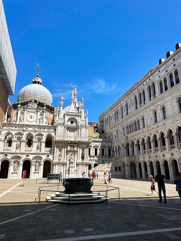 St Mark's Square, Venice, Italy - July, 12 2023: Stock photo showing close-up view of tourists milling around St Mark's Square (Piazza San Marco) and walking past the Doge's Palace (Palazzo Ducale) toward St Mark's Cathedral (Basilica di San Marco).