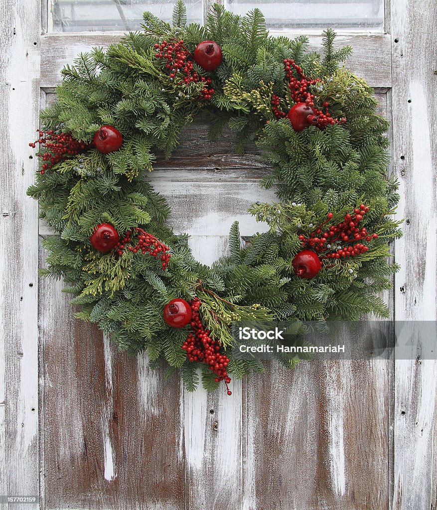 Christmas wreath hanging on a white-washed wooden door Christmas wreath on a rustic wooden front door. Christmas Stock Photo