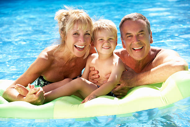großeltern und enkel spaß im pool - active seniors retirement enjoyment swimming pool stock-fotos und bilder