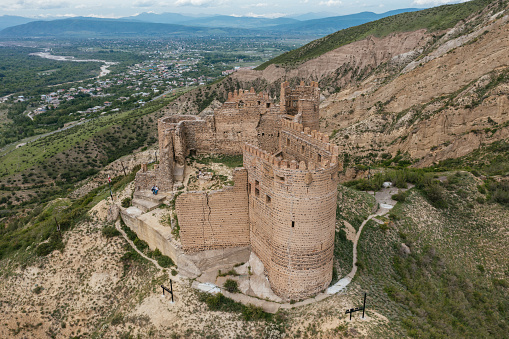 Ancient old fortress. Mukhrani Ksani Castle ruin in mountains, aerial drone view.