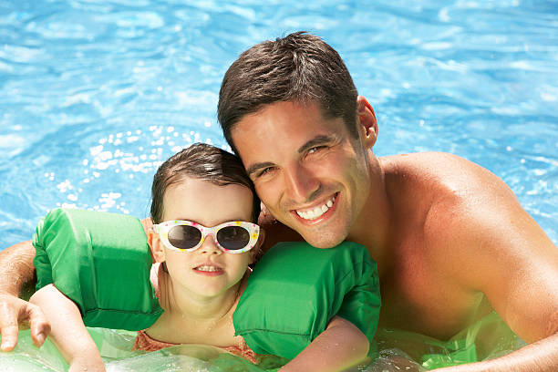 istock Father And Daughter With Armbands In Swimming Pool 157703105