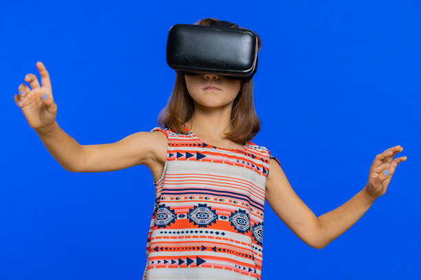 istock Child kid girl using headset helmet app to play simulation game, watching virtual reality 3D video 1577067750