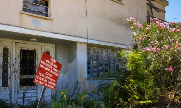 Photo of Abandoned house in Varosha with a warning sign, the southern quarter of Famagusta, ghost town under control of the United Nations, Northern Cyprus, Turkish side of the island