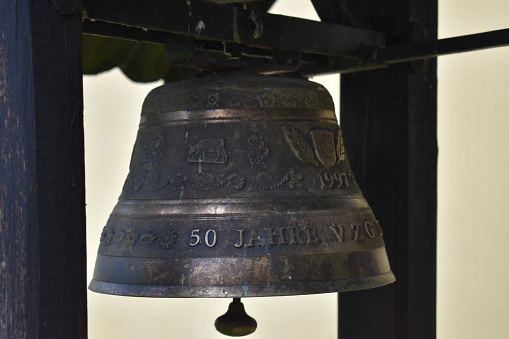 The church bell resonates with a timeless charm, calling worshippers to gather and mark sacred moments