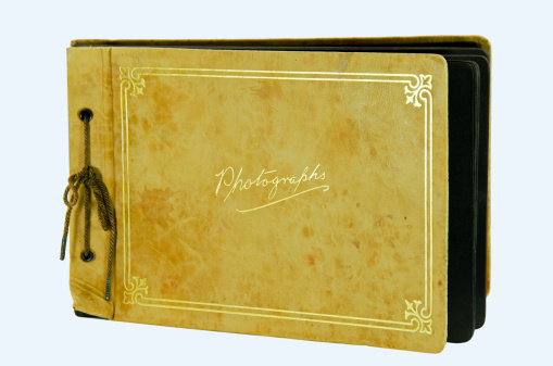 Vintage leather covered photograph album on a white background. Gold embossed letters.