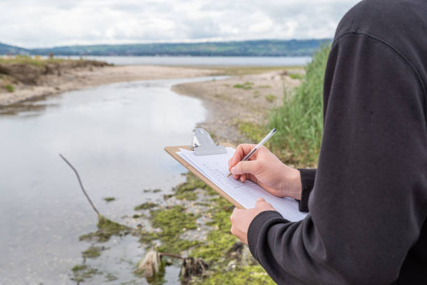 Making field observations of a river and coastline with a clipboard and pen