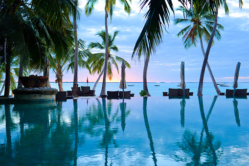 The Swimming Pool of Summer Resort with Sunset Background