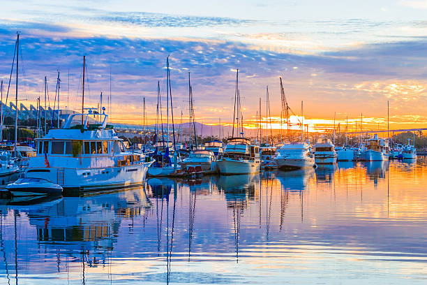 boats, marina at dawn, sunrise clouds, San Diego Harbor, California Dawn, sunrise. Pleasure boats, marina, sunrise clouds, colorful reflections in water. San Diego Harbor, California. Copy space in sky in upper quarter of photo. Also copy space in water in lower quarter of photo. marina photos stock pictures, royalty-free photos & images