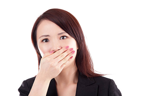 испуганный китайский деловая женщина, охватывающий рот рукой на белом фоне - female young adult isolated gasping стоковые фото и изображения