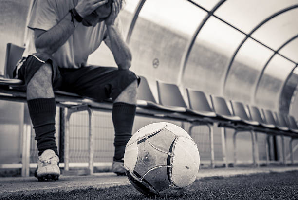 Soccer player sitting on bench Disappointed soccer player sitting on the bench soccer player photos stock pictures, royalty-free photos & images