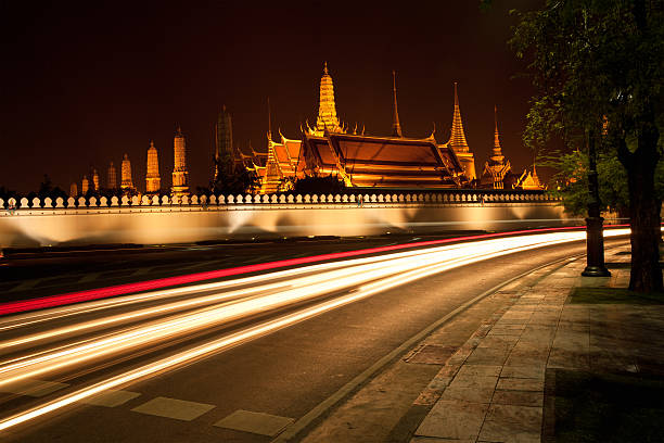 Long exposure of cars whizzing by during the night in front of Wat Phra Kaew Grand Palace in Bangkok, Thailand (Temple of the Emerald Buddha).