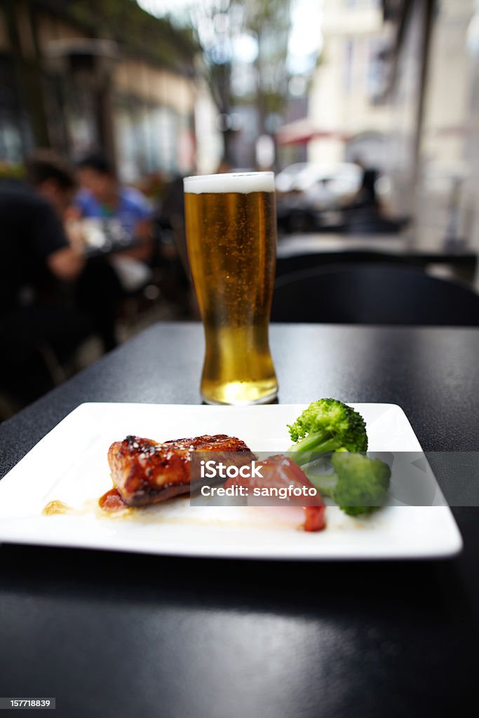 Salmón asado con verduras y cerveza fría - Foto de stock de Aire libre libre de derechos