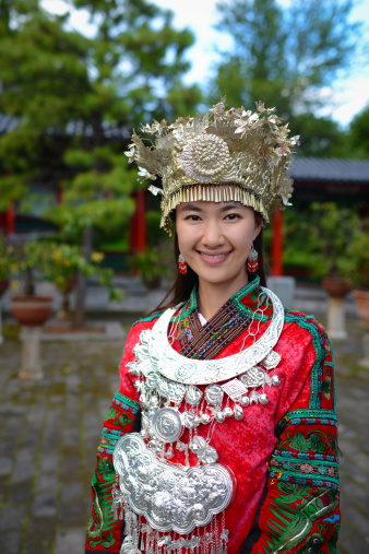 The portrait of beautiful woman of Miao Minority with traditional clothing, China