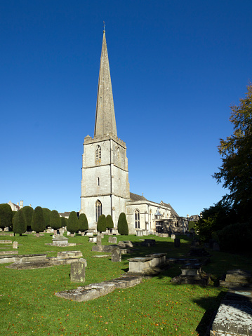 The historic church and churchyard yew trees at Painswick in the Cotswolds, Gloucestershire, UK. Wide-angle composite image.