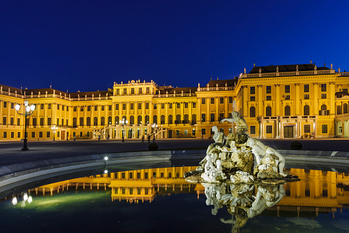 Vienna, Austria - September 9, 2012: It's dusk and only few people are still strolling in the Schonbrunn Palace park. They are the last of the usual crowd of people who every day visit this magnificent palace, which in earlier times was the summer residence to various Habsburg rulers. Its surrounding buildings and the huge park have been added to the UNESCO's world cultural heritage list in 1996.