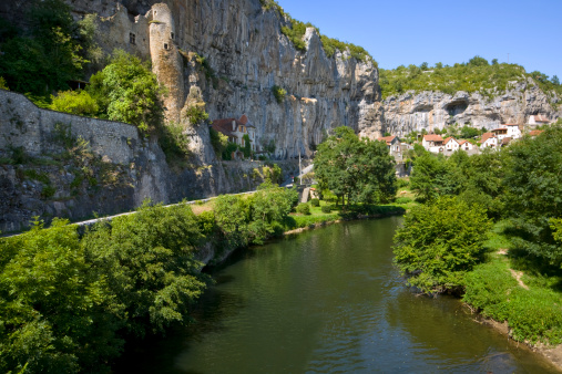 The picturesque Cele Valley and river at Cabrerets where some homes are built under the cliffs in The Lot, France, Europe