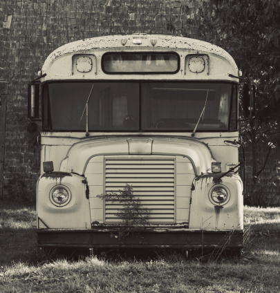An abandoned school bus.  Toned black and white.