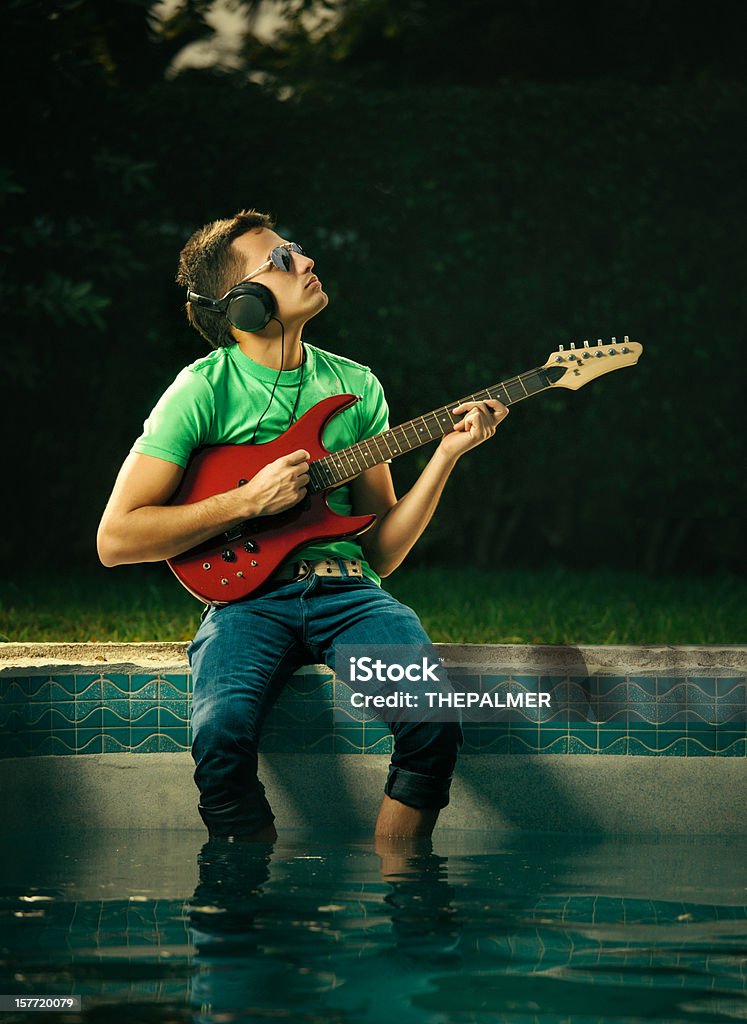 Giovane ragazzo suona Chitarra elettrica in piscina - Foto stock royalty-free di Acqua