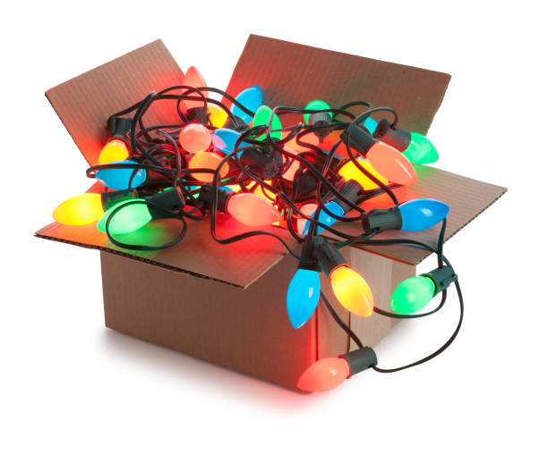 A cardboard box of lit up tangled string of C9 Christmas lights isolated on white. Clipping path provided. Cleaned up in Photoshop.