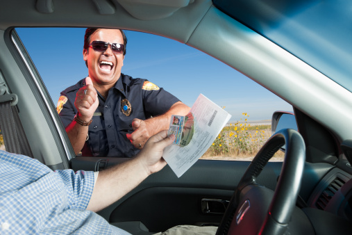 A dishonest motorist hands a traffic law enforcement officer his license and registration along with several 20 dollar bills as a bribe to get out of a moving violation or speeding ticket. The dirty cop celebrates his good fortune by doing a little victory dance outside the vehicle.