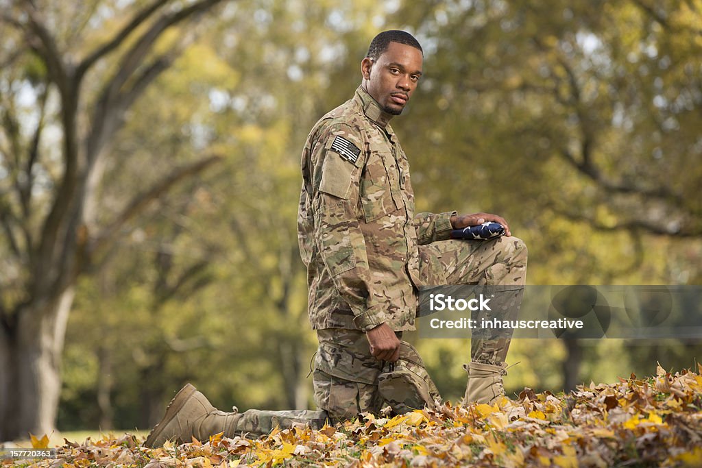 Inginocchiarsi soldato pregare su una bandiera americana - Foto stock royalty-free di 25-29 anni