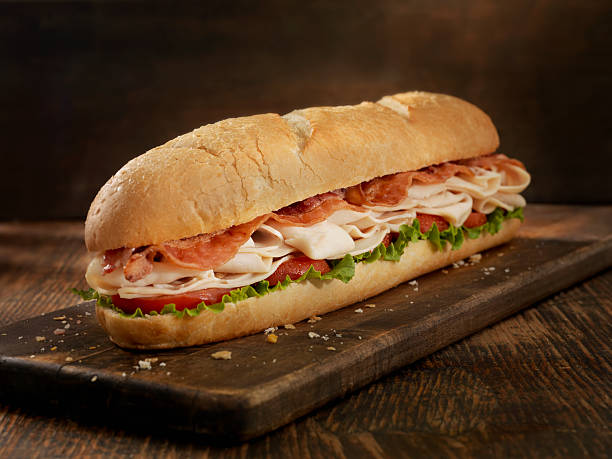 Foot Long Turkey and Bacon Sub 12 inch - Turkey and Bacon Submarine Sandwich with Lettuce and Tomato on a Crusty Bun- Photographed on Hasselblad H3D2-39mb Camera cheddar cheese photos stock pictures, royalty-free photos & images