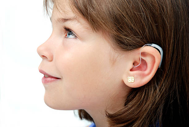 Hearing aid Seven years old with a last model hearing aid device in her ear. ear horn photos stock pictures, royalty-free photos & images