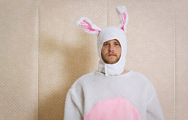 An unhappy man, dressed in a bunny outfit stock photo