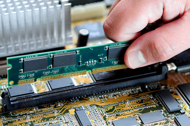 Male Hand Installing Memory on Computer Motherboard stock photo